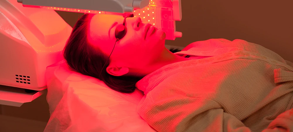 a women enjoying red light therapy on face with eye protective google